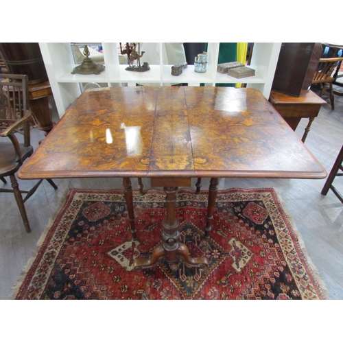 7608 - A walnut burr wood veneer drop flap Sutherland table on scroll feet, opened 113.5cm x 94cm x 73cm