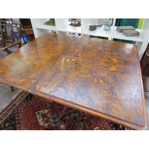 7608 - A walnut burr wood veneer drop flap Sutherland table on scroll feet, opened 113.5cm x 94cm x 73cm