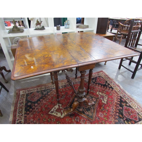 7608 - A walnut burr wood veneer drop flap Sutherland table on scroll feet, opened 113.5cm x 94cm x 73cm