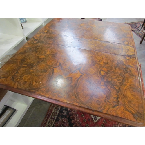 7608 - A walnut burr wood veneer drop flap Sutherland table on scroll feet, opened 113.5cm x 94cm x 73cm