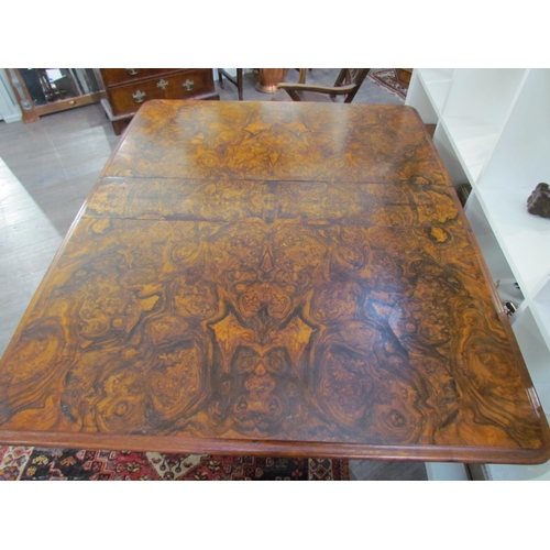 7608 - A walnut burr wood veneer drop flap Sutherland table on scroll feet, opened 113.5cm x 94cm x 73cm