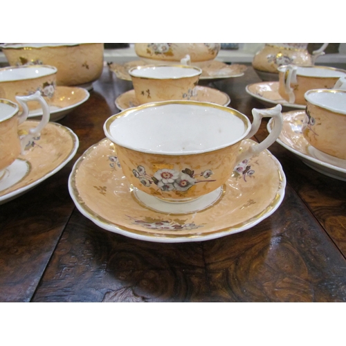 7609 - A quantity of Rockingham porcelain tea wares, peach ground with handpainted floral sprays enriched w... 