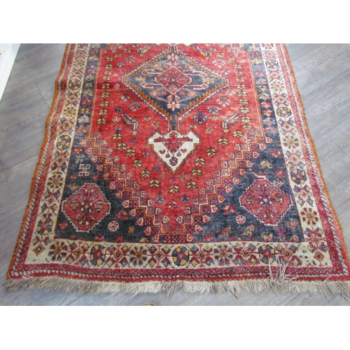 7610 - A Persian hand knotted wool rug, red ground with birds and floral borders, 155cm x 115cm