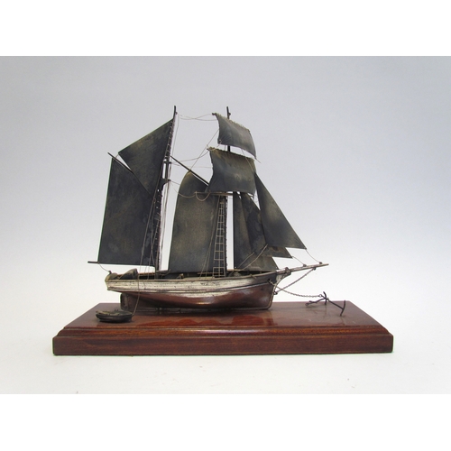 7620 - A silver model of a sailing vessel, hallmark indistinct, 22cm tall, on plinth base