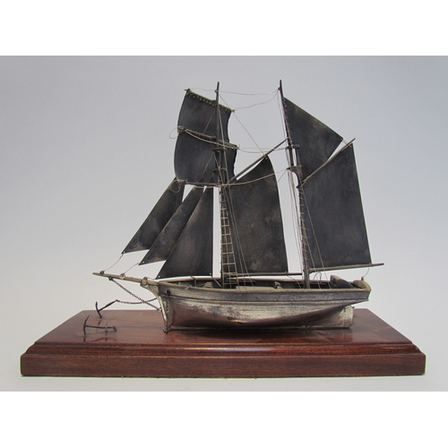 7620 - A silver model of a sailing vessel, hallmark indistinct, 22cm tall, on plinth base