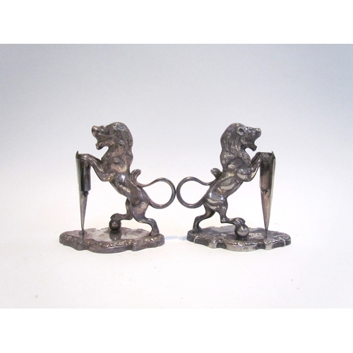 7631 - A pair of Walker & Hall silver plated lions with shields, stamped 17044 to base, each 12.5cm tall