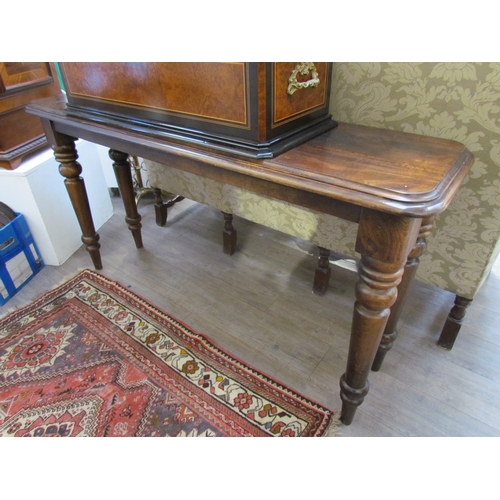 7645 - A reproduction mahogany console table, round-cornered top over turned supports, 157cm x 86cm x 46cm ... 