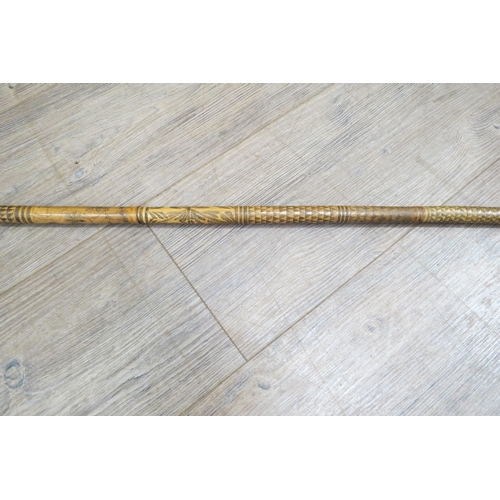 7759A - A 19th Century bamboo blow pipe, all over decoration of patterns, foliage and animals, 133cm long