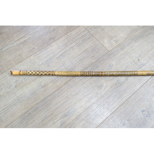 7759A - A 19th Century bamboo blow pipe, all over decoration of patterns, foliage and animals, 133cm long