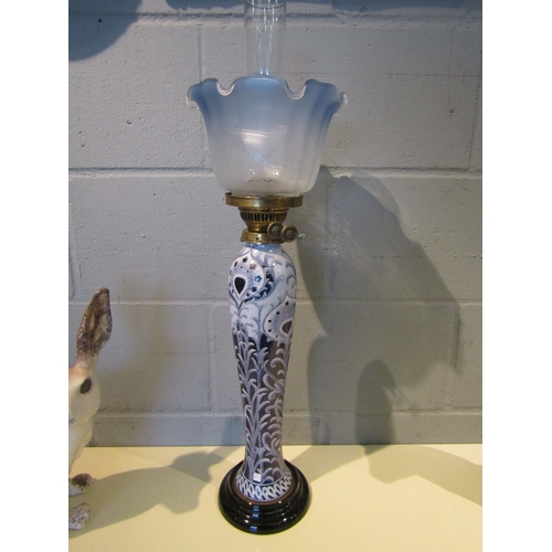 1091 - A Moorcroft style oil lamp, twin burner, blue tinted shade, funnel porcelain base, 62cm tall