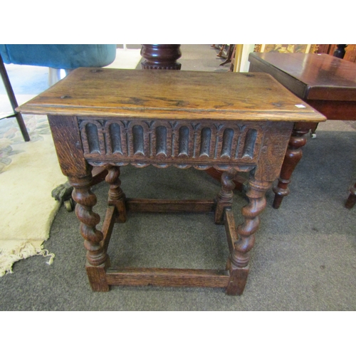 1119 - A carved oak stool on barley twist legs to stretcher base