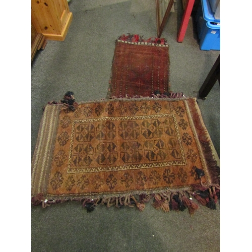 1128 - An Eastern tasseled rug, burnt orange triangles, double sided, 113cm x 65cm and a similar maroon gro... 