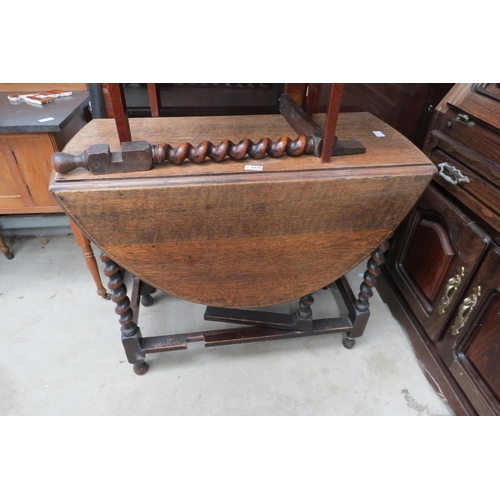 2376 - A 1920's oak gateleg table with barleytwist supports,one leg lose