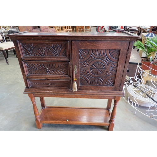 2106 - A carved oak three drawer one door cabinet on stand   (E)  £40-60