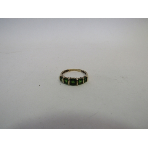 1410 - A 9ct gold ring set with five green stones. Size P, 2.3g