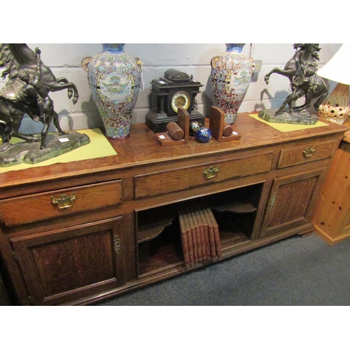 1061 - A Georgian oak sideboard, three drawers over shelved recess flanked by cupboard doors, bracket feet,... 