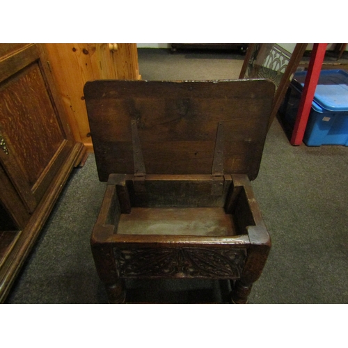 1068 - A 19th Century and later carved oak stool with lift-up top, 38cm tall x 44cm wide x 27cm deep