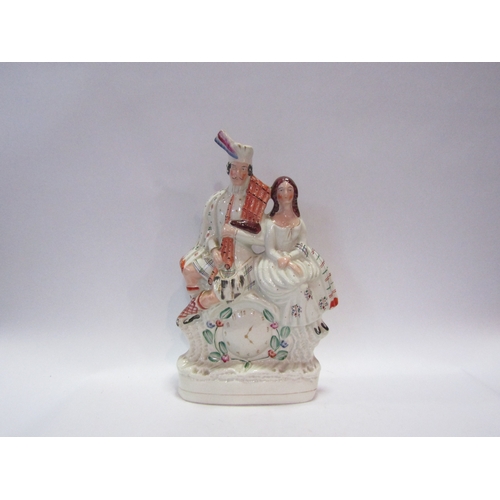 1233 - A 19th Century clock figural group, a highlander with bagpipes sat beside female, 35cm tall (a/f)