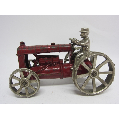 9244 - A red painted cast iron tractor with polished metal wheels and driver, in the manner of Arcade, 16.5... 