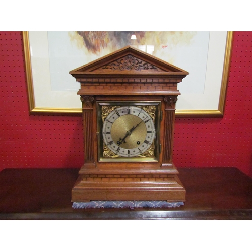 4027 - An oak cased mantel clock with engraved column design to case, cherubs to corners of face. Roman num... 