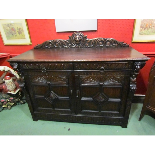 4048 - A late Victorian carved oak sideboard with lion's head and winged angel decoration, the two drawers ... 