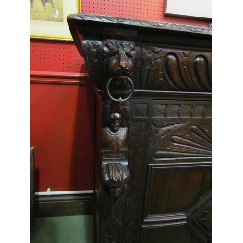 4048 - A late Victorian carved oak sideboard with lion's head and winged angel decoration, the two drawers ... 