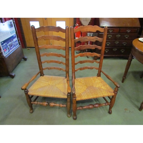 4064 - A pair of ladder-back rush seated chairs. Low seat height (35cm)   (E) £30-45