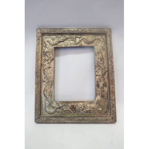 1295 - An Oriental white metal frame with dragon design, 33cm x 27cm