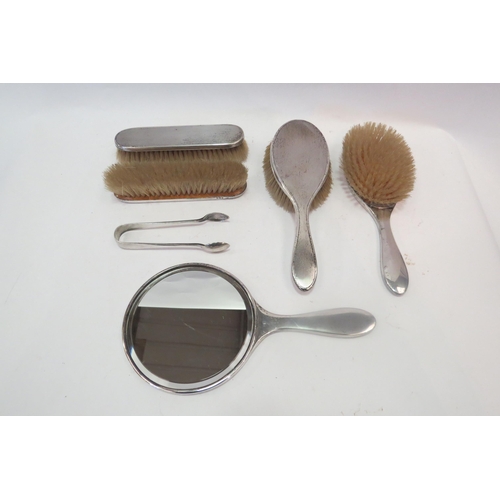 1351 - A silver backed dressing table set with plated tongs