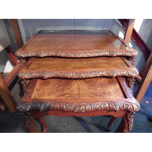 1008 - A carved mahogany nest of three occasional tables, missing one glass top