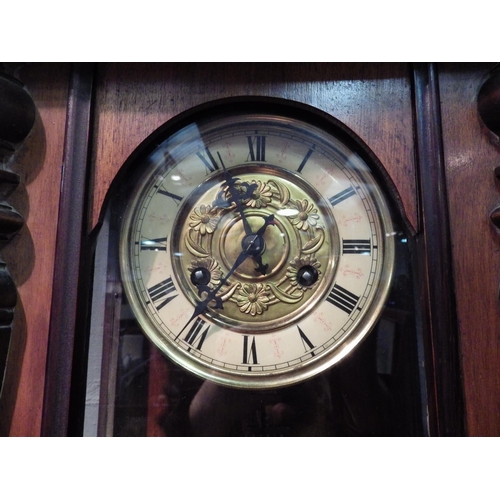 1033 - An early 20th Century mahogany Vienna wall clock, Roman numerated chapter ring, heavily carved pedim... 