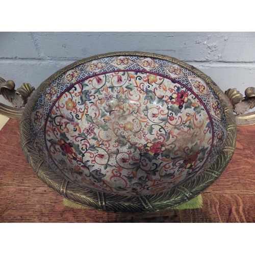 1036 - A large gilt metal mounted twin handled ceramic bowl with floral design, 21cm tall x 55cm wide