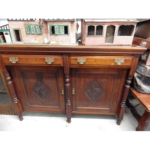 2447 - An Edwardian mahogany two drawer over two door sideboard with brass handles and carved decoration