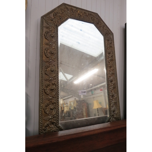 2160 - A decorative brass embossed framed bevelled edged mirror