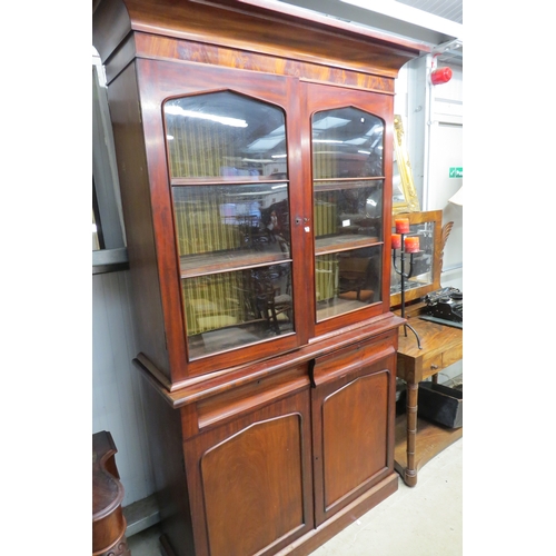 2171 - An early Victorian mahogany glazed top bookcase on cupboard with two cushion drawers   (R) £100