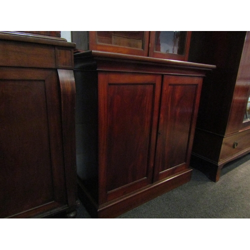 1028A - A mid Victorian flame mahogany two door cupboard with key on a plinth base, 98cm tall x 92cm wide x ... 