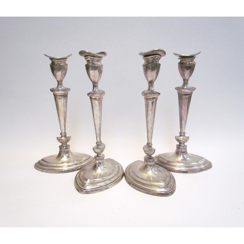 4060 - A late Victorian set of four silver candlesticks in the Georgian form, tapering column, one wax pan ... 