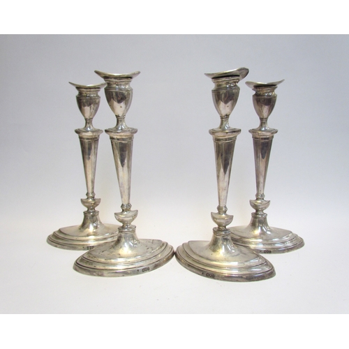 4060 - A late Victorian set of four silver candlesticks in the Georgian form, tapering column, one wax pan ... 