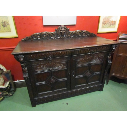 4062 - A late Victorian carved oak sideboard with lion's head and winged angel decoration, the two drawers ... 