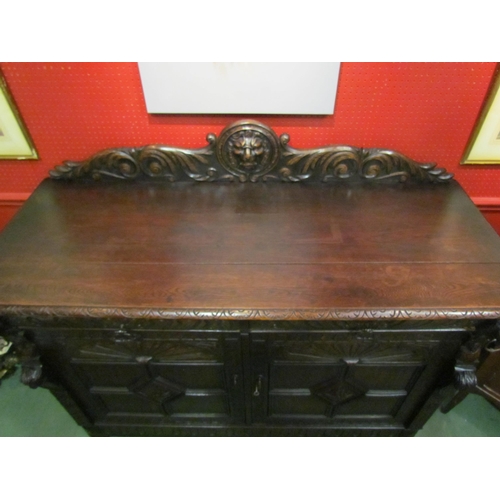 4062 - A late Victorian carved oak sideboard with lion's head and winged angel decoration, the two drawers ... 