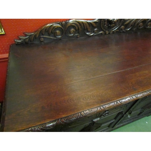 4062 - A late Victorian carved oak sideboard with lion's head and winged angel decoration, the two drawers ... 