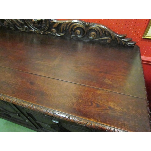 4062 - A late Victorian carved oak sideboard with lion's head and winged angel decoration, the two drawers ... 