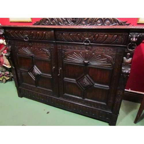 4062 - A late Victorian carved oak sideboard with lion's head and winged angel decoration, the two drawers ... 