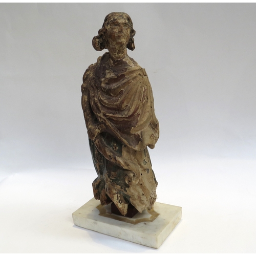 4093 - A 17th Century European carved lime wood figure of a saint in a time worn state mounted on a marble ... 