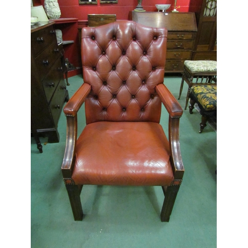 4121 - A George III style leather Gainsborough armchair the deep button and brass studded backrest over squ... 