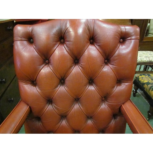 4121 - A George III style leather Gainsborough armchair the deep button and brass studded backrest over squ... 