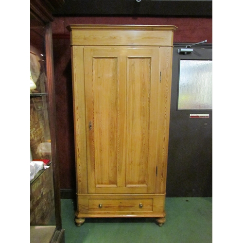 4163 - A 19th Century stripped pine French single door armoire with key and base drawer on turned feet and ... 