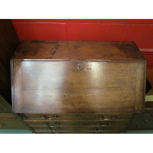 4167 - A George III provincial oak bureau, the fully fitted interior of eight drawers, central cupboard and... 