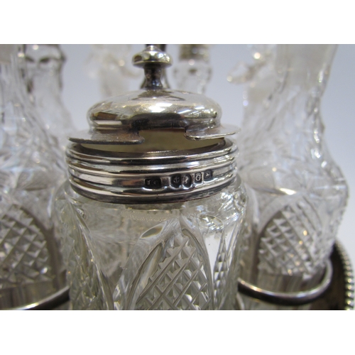 4387 - A Victorian silver plate cruet stand with swivel 7 bottle container, 3 with silver lids. Floral embo... 