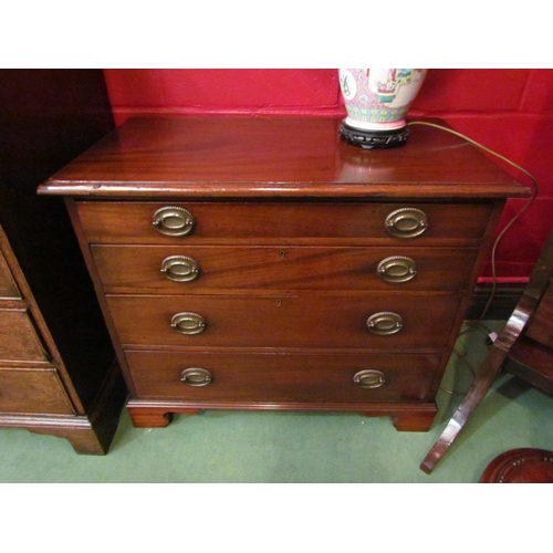 4133 - A Georgian flame mahogany chest of small proportions, the four graduating long drawers with oval bac... 